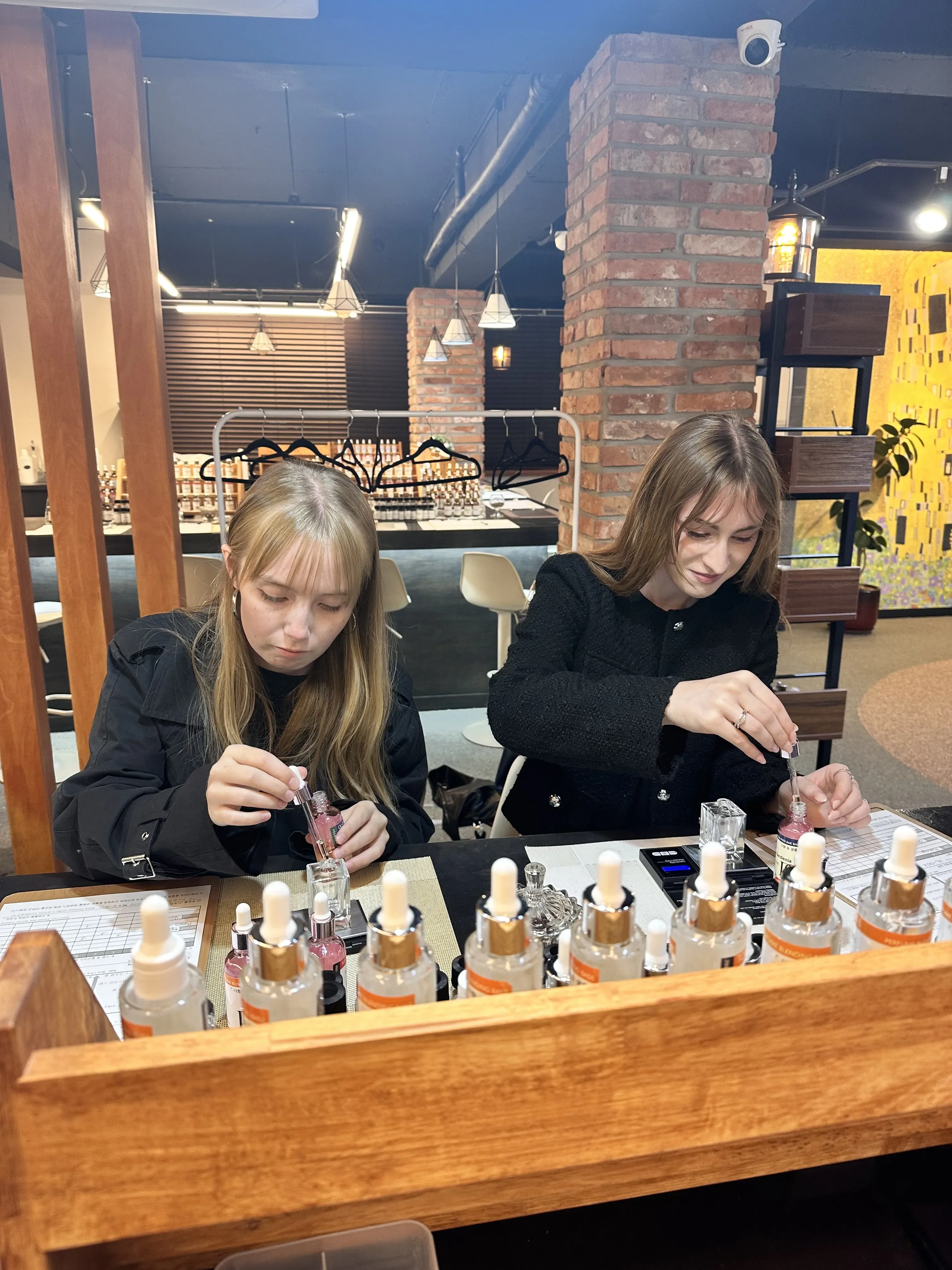 Friends measuring fragrance ingredients for custom perfume
