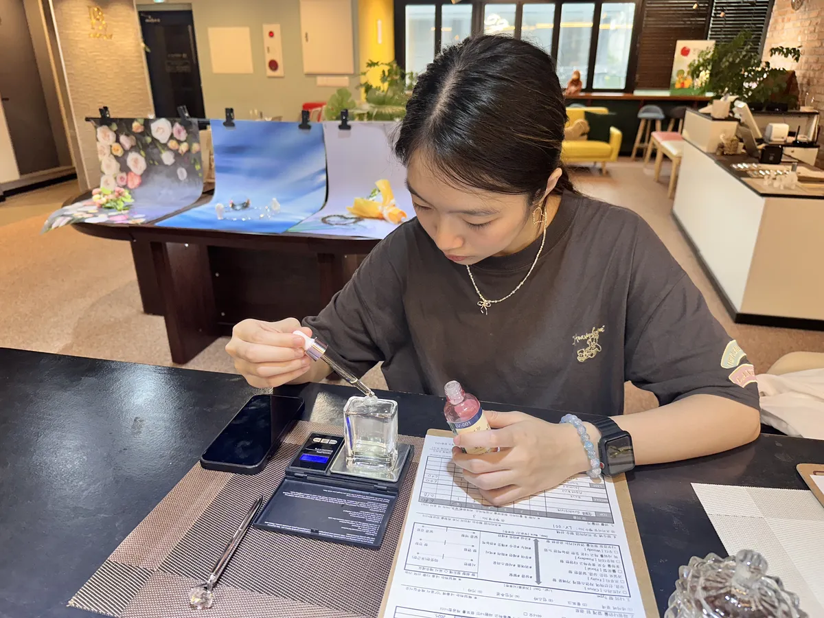 Customer blending a custom perfume using a scale